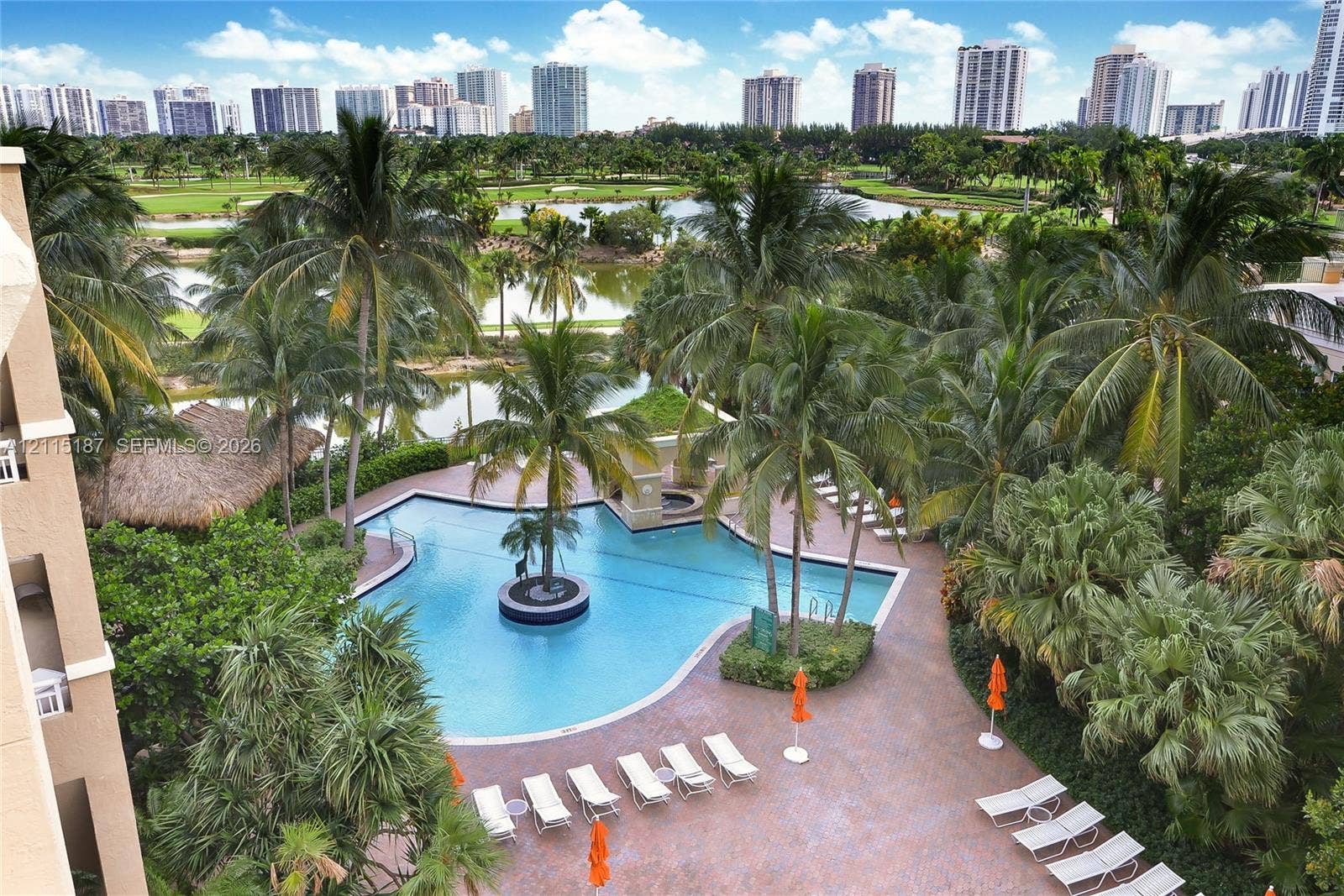 19501 W Country Club Drive, #504, Aventura, Aventura, FL 33180 Swimming pool with a centered palm tree, paved pool deck, and mature palm landscaping