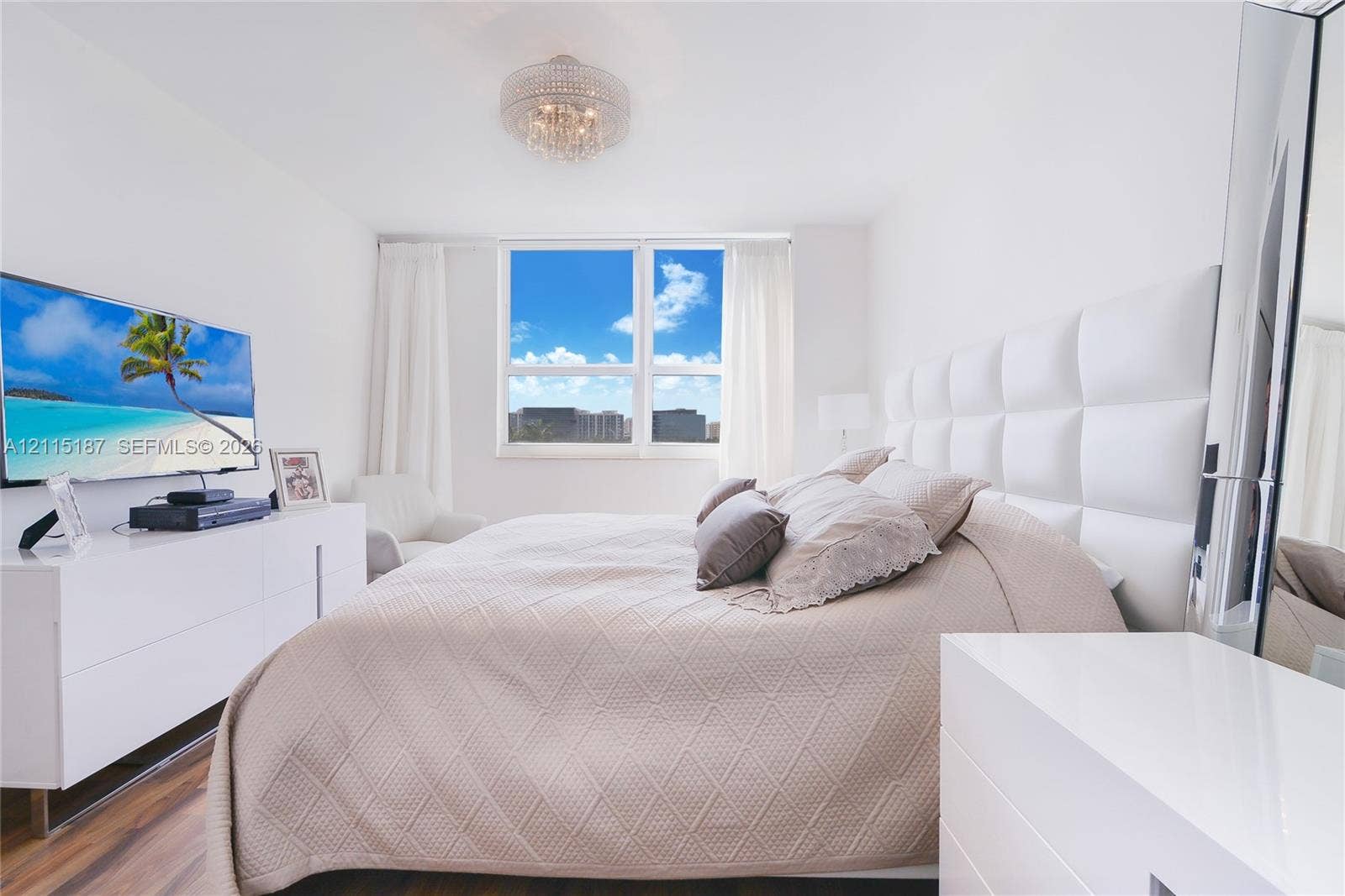 19501 W Country Club Drive, #504, Aventura, Aventura, FL 33180 Bedroom featuring wood-finish flooring, a large multi-pane window, and a decorative crystal-style flush-mount ceiling light fixture