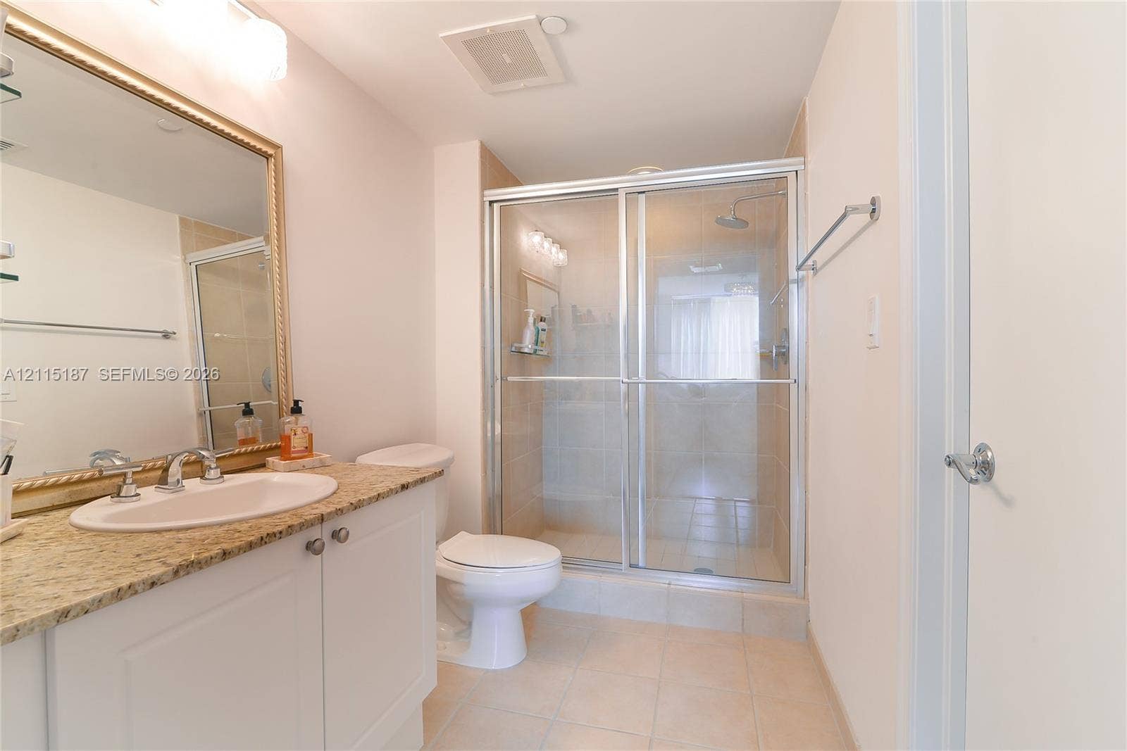 19501 W Country Club Drive, #504, Aventura, Aventura, FL 33180 Bathroom featuring a vanity with a stone-finish countertop, undermount sink, framed wall mirror, and a walk-in glass-enclosed shower