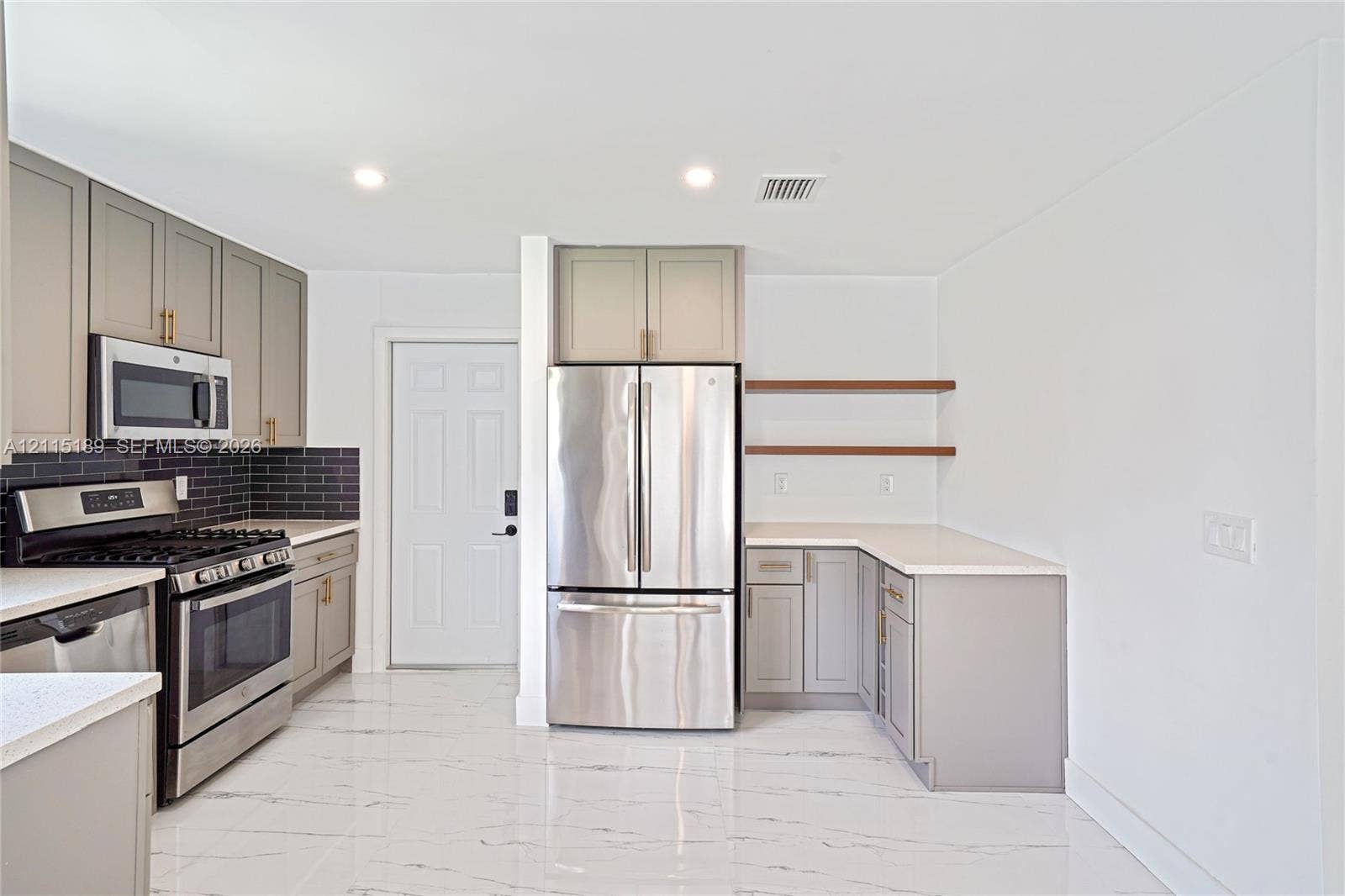 2111 N 14th Court, Hollywood, Hollywood, FL 33020 Kitchen featuring shaker-style cabinetry, stainless steel appliances, quartz countertops, dark subway tile backsplash, and polished stone-finish flooring