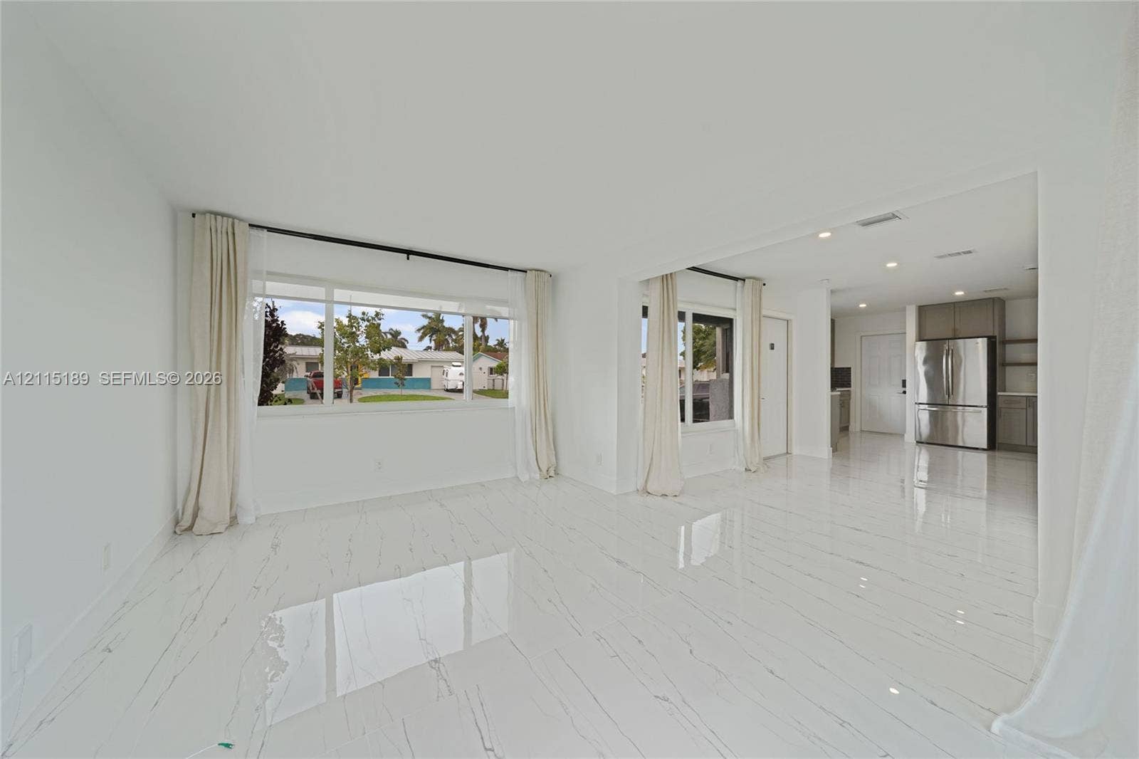 2111 N 14th Court, Hollywood, Hollywood, FL 33020 Open-concept interior featuring polished tile flooring, large multi-pane windows, recessed ceiling lighting, and stainless steel kitchen appliances