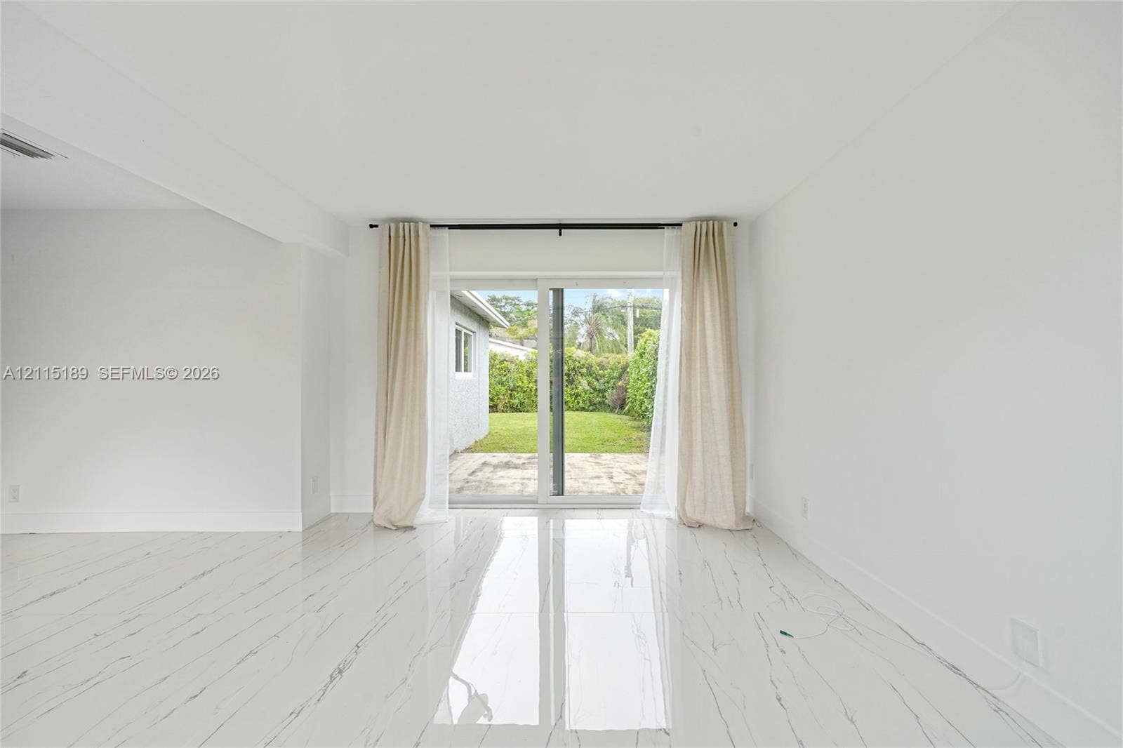2111 N 14th Court, Hollywood, Hollywood, FL 33020 Interior space featuring large-format tile flooring with veining, white walls, and a sliding glass door