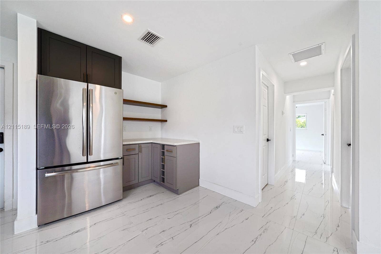 2111 N 14th Court, Hollywood, Hollywood, FL 33020 Stainless steel French-door refrigerator, custom cabinetry with integrated wine storage, quartz countertops, floating wall shelving, and polished stone-finish flooring