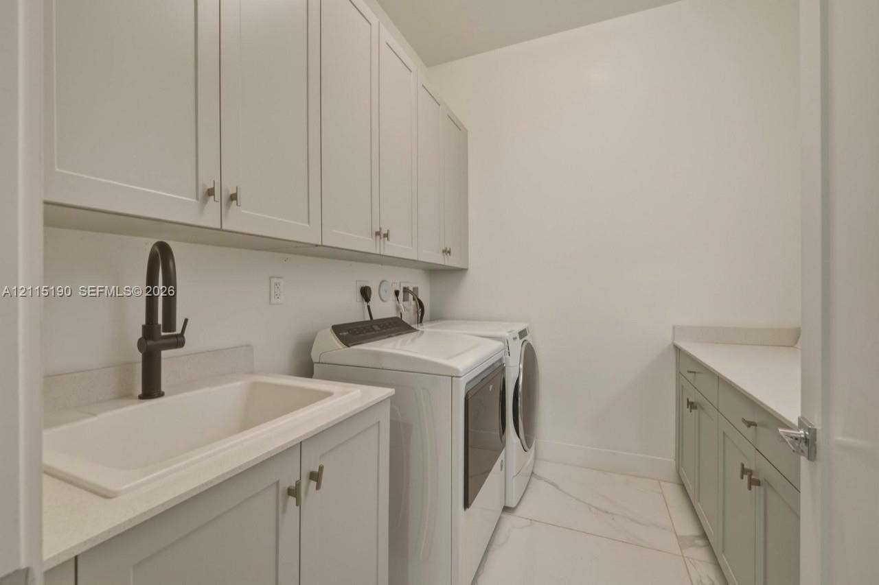 Laundry room with sink and cabinetry.