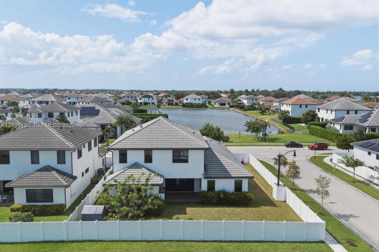 Rear aerial view of the home and fenced yard.