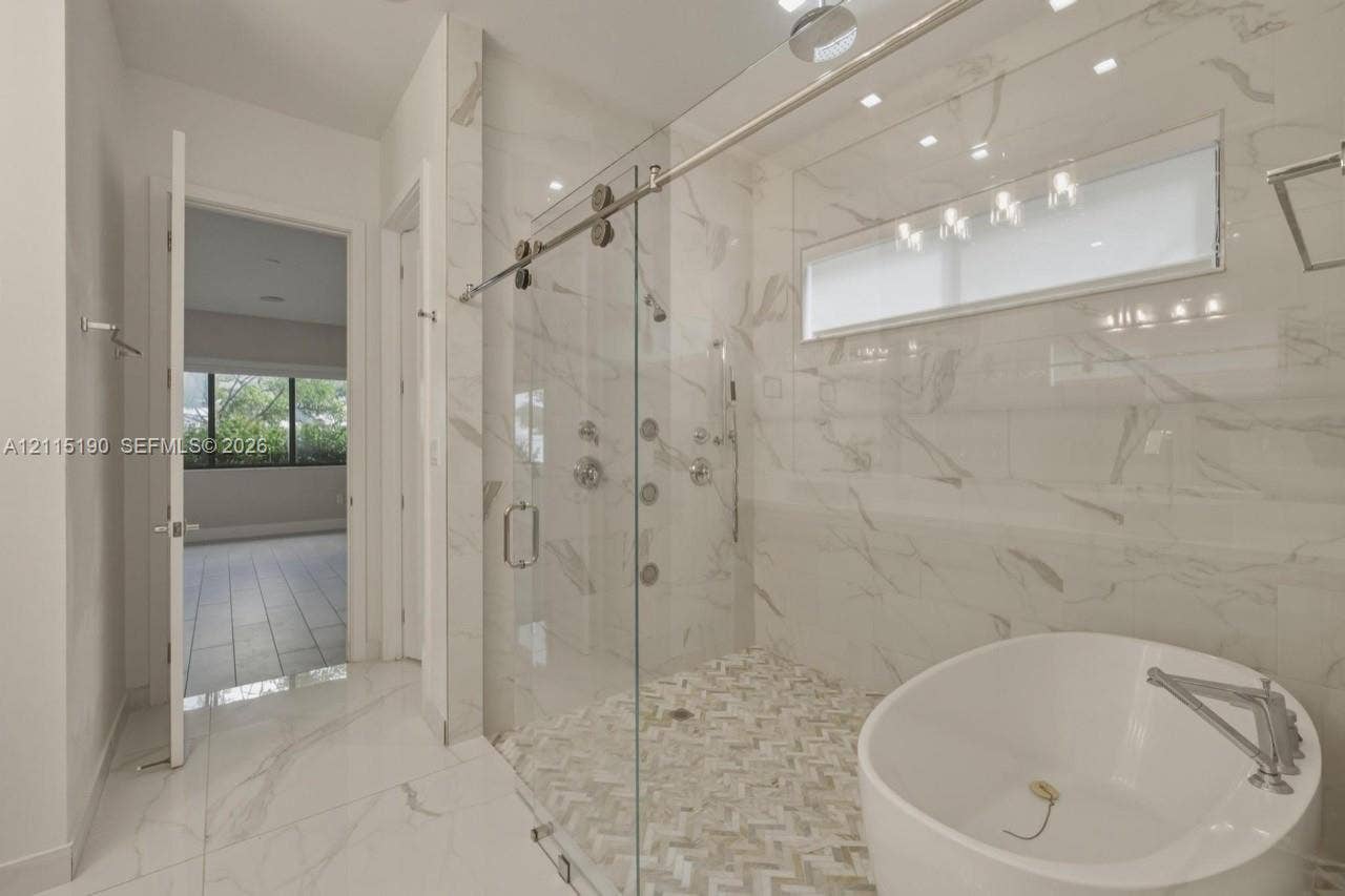 Bathroom with freestanding tub and separate glass-enclosed shower.