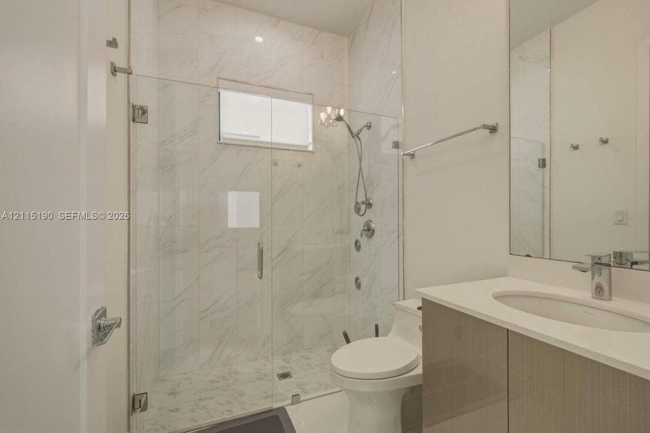 Full bathroom with glass-enclosed shower.
