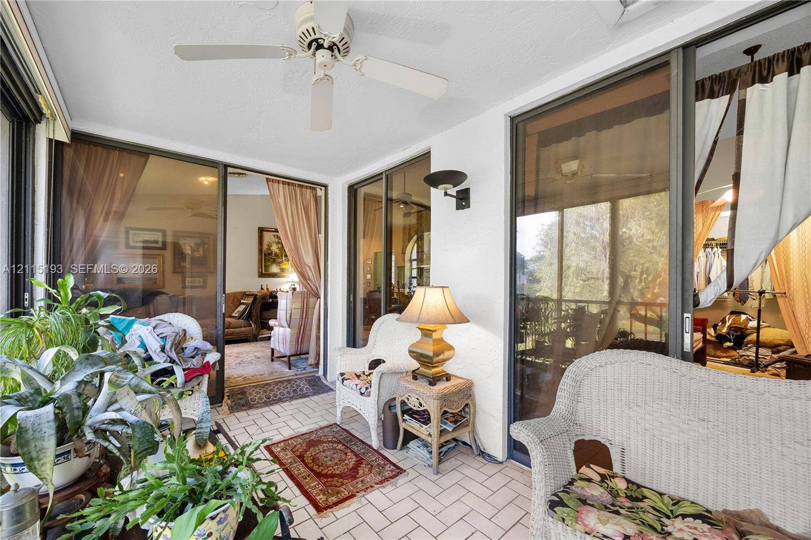 5422 Venetia Court, #G, Boynton Beach, FL 33437 Enclosed patio featuring ceramic tile flooring, a ceiling-mounted fan, and wall-mounted light fixtures with large glass sliding doors