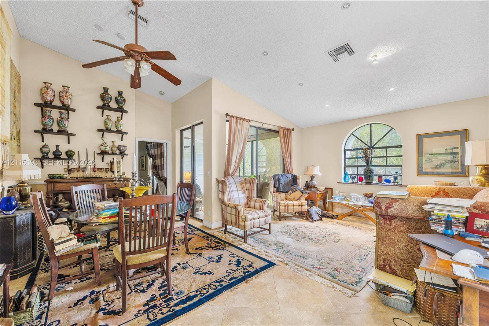 5422 Venetia Court, #G, Boynton Beach, FL 33437 Living area featuring vaulted ceilings, stone-finish tile flooring, recessed lighting, a ceiling fan, and a large arched window