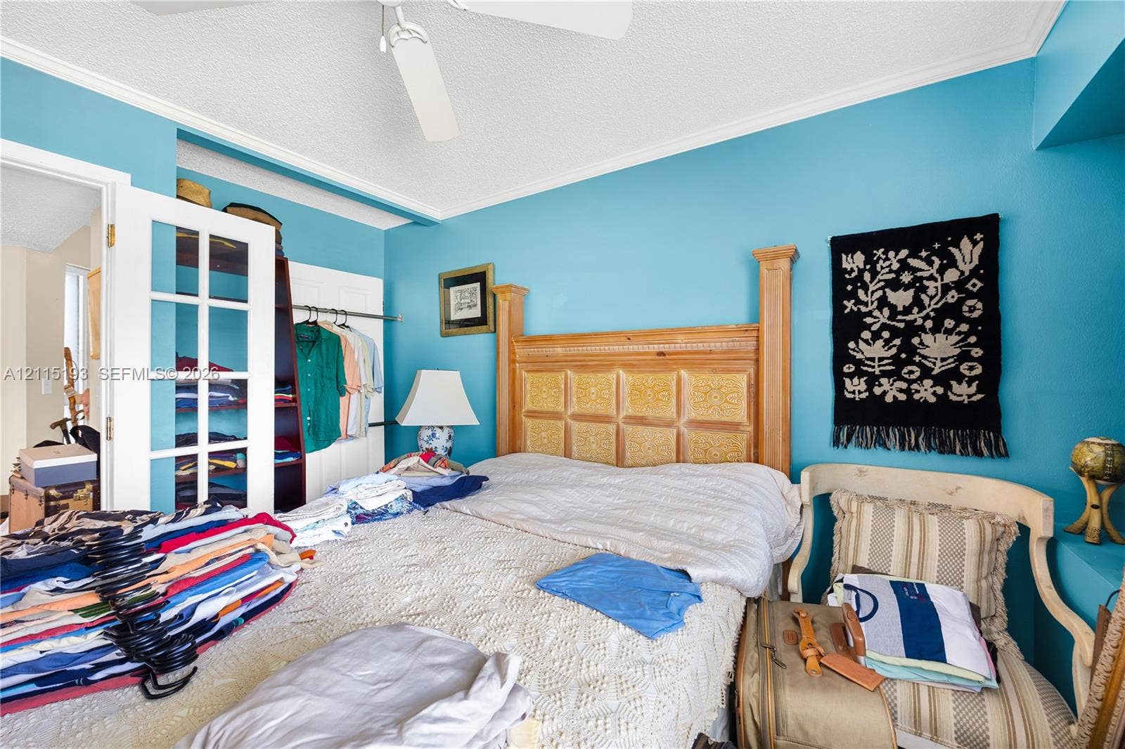 5422 Venetia Court, #G, Boynton Beach, FL 33437 French-door closet entry featuring white trim, ceiling-mounted paddle fan, and crown molding