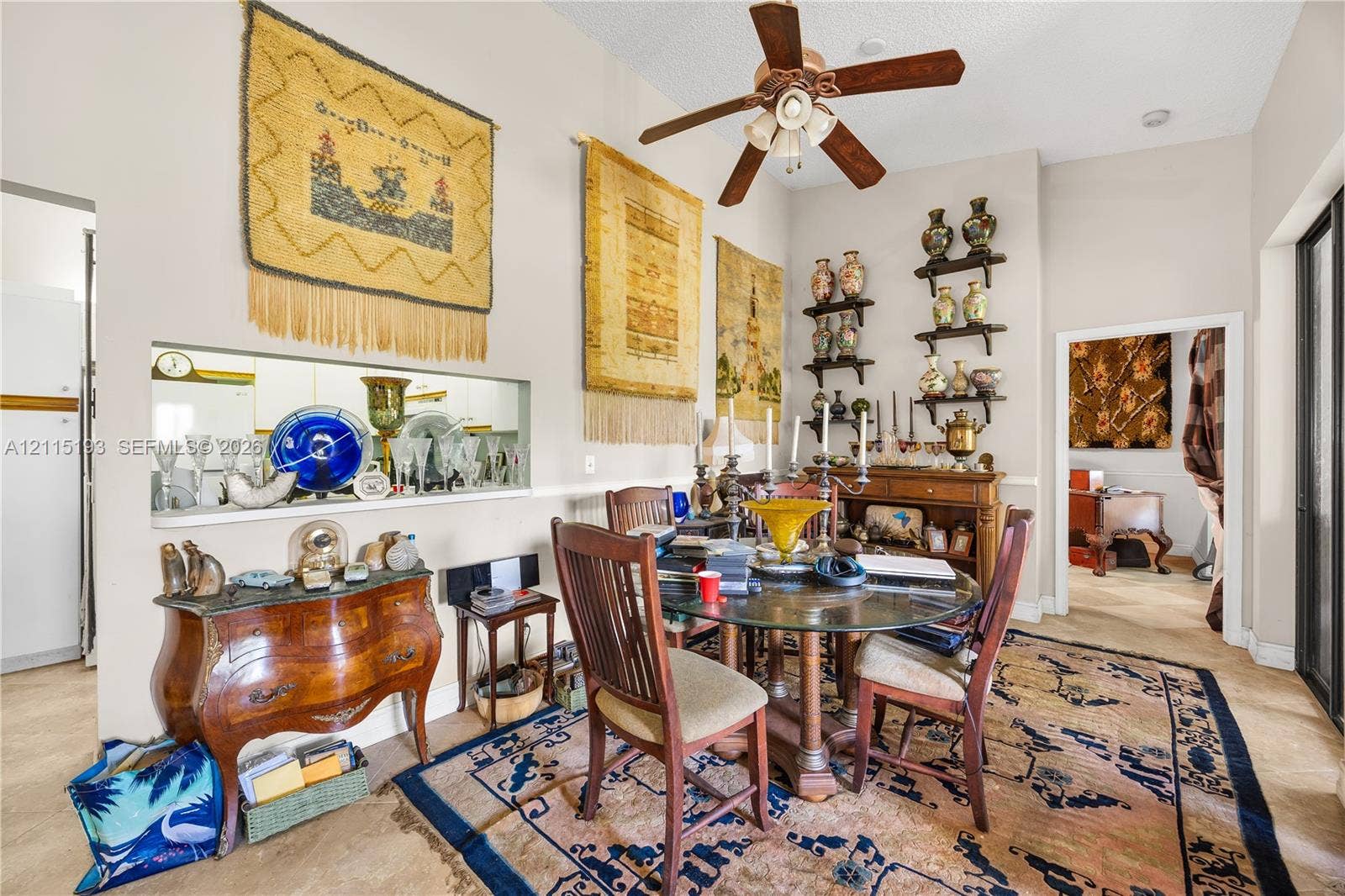 5422 Venetia Court, #G, Boynton Beach, FL 33437 Dining area featuring vaulted ceilings, a central ceiling fan with integrated lighting, and a pass-through window to the kitchen