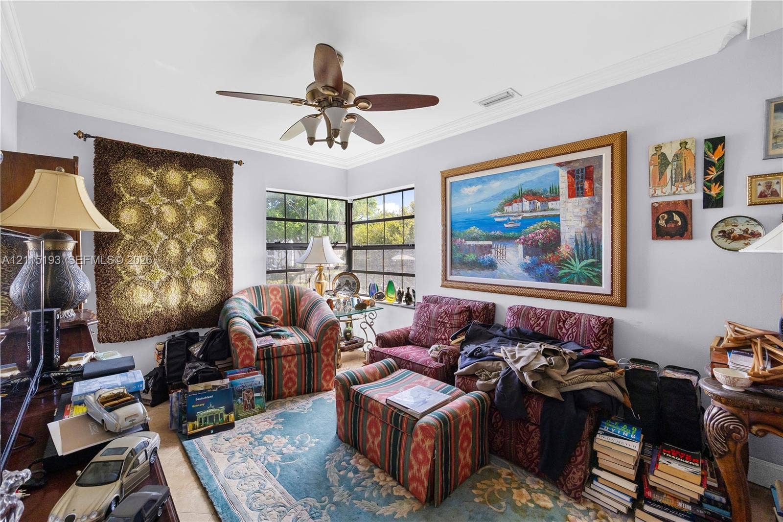 5422 Venetia Court, #G, Boynton Beach, FL 33437 Living area featuring crown molding, multi-pane windows, and a ceiling fan with integrated lighting