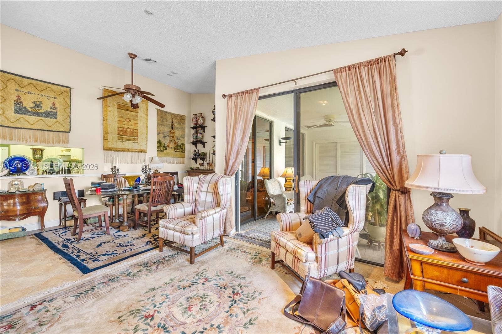 5422 Venetia Court, #G, Boynton Beach, FL 33437 Vaulted ceiling with a central paddle fan, built-in recessed niche shelving, and large sliding glass doors