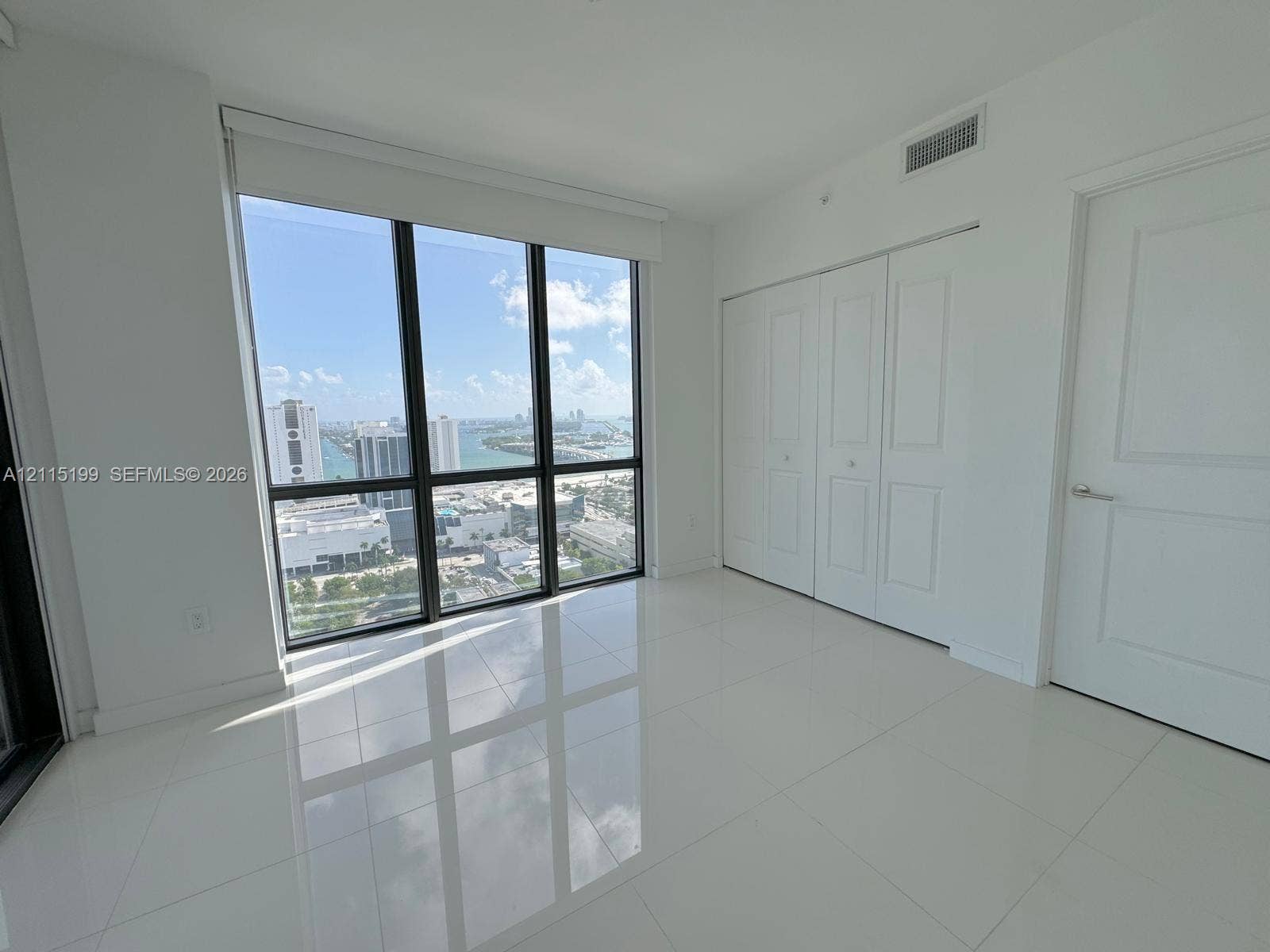 1600 NE 1st Avenue, #3120, Miami, FL 33132 Floor-to-ceiling windows, polished tile flooring, white-panel bifold closet doors, and solid-core door with metallic hardware