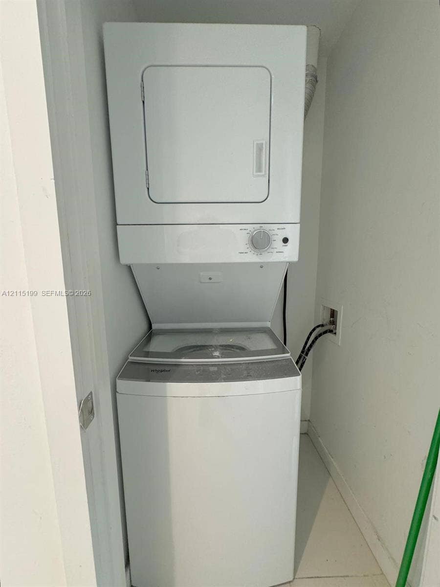 1600 NE 1st Avenue, #3120, Miami, FL 33132 Stacked white laundry center featuring a top-loading washer and front-loading dryer unit housed within a dedicated enclosure