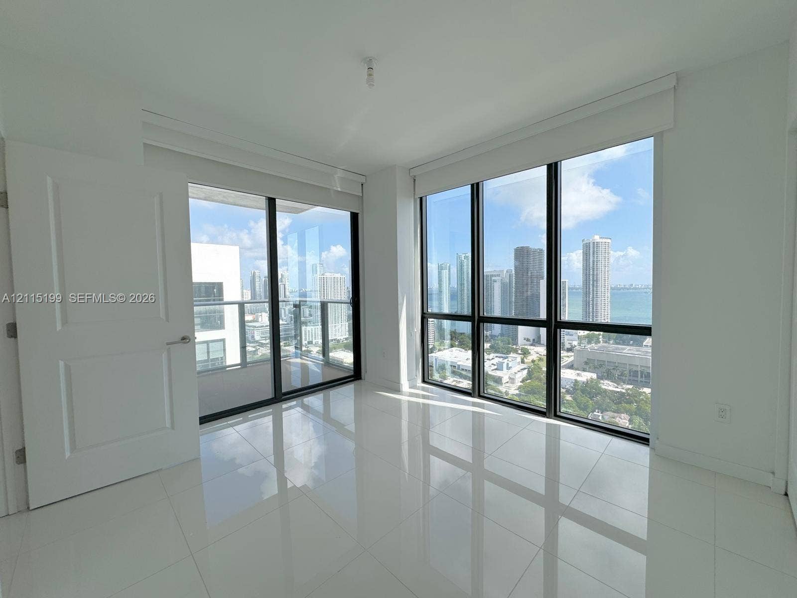 1600 NE 1st Avenue, #3120, Miami, FL 33132 Floor-to-ceiling windows with black frames, polished tile flooring, glass-railed balcony, and skyline scenery
