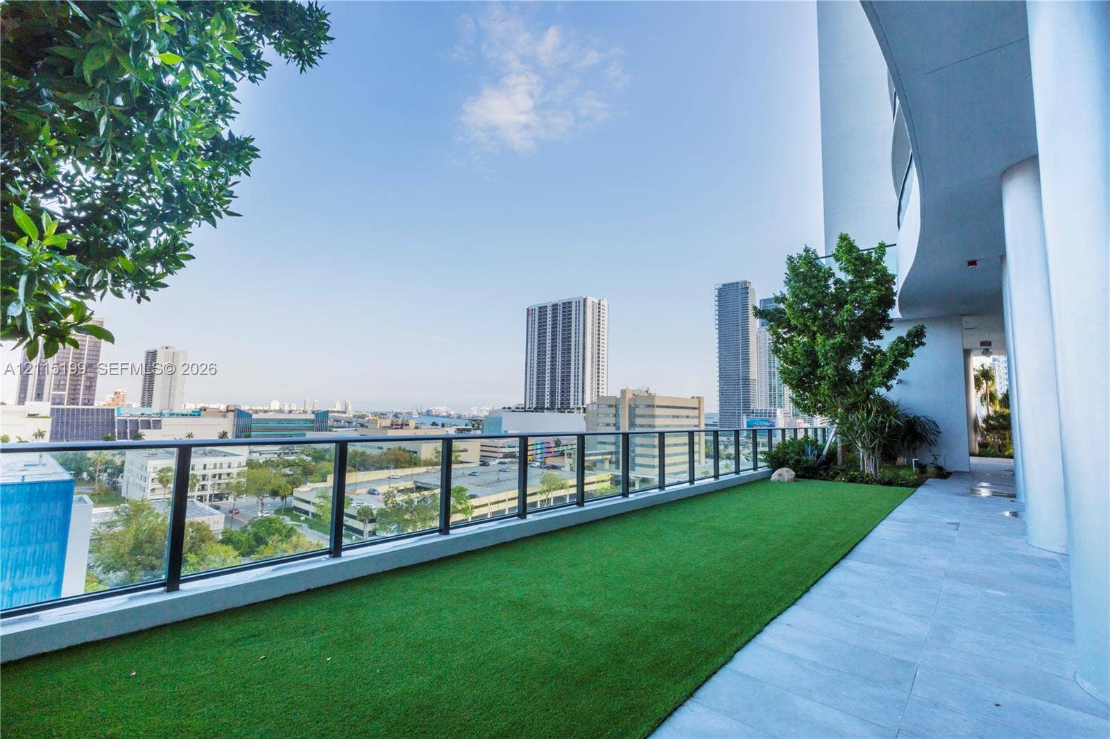 1600 NE 1st Avenue, #3120, Miami, FL 33132 Covered terrace featuring large-format tile flooring, artificial turf, structural columns, and a glass-paneled railing