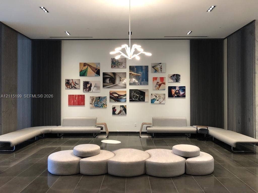 1600 NE 1st Avenue, #3120, Miami, FL 33132 High-ceilinged interior featuring large-format tile flooring, recessed architectural lighting, and a multi-arm modern pendant fixture
