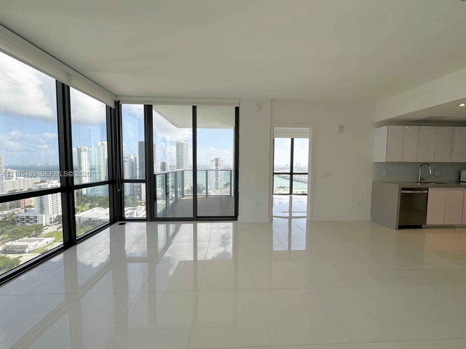 1600 NE 1st Avenue, #3120, Miami, FL 33132 Floor-to-ceiling windows, private balcony, polished tile flooring, and kitchen featuring white cabinetry with integrated stainless steel appliances