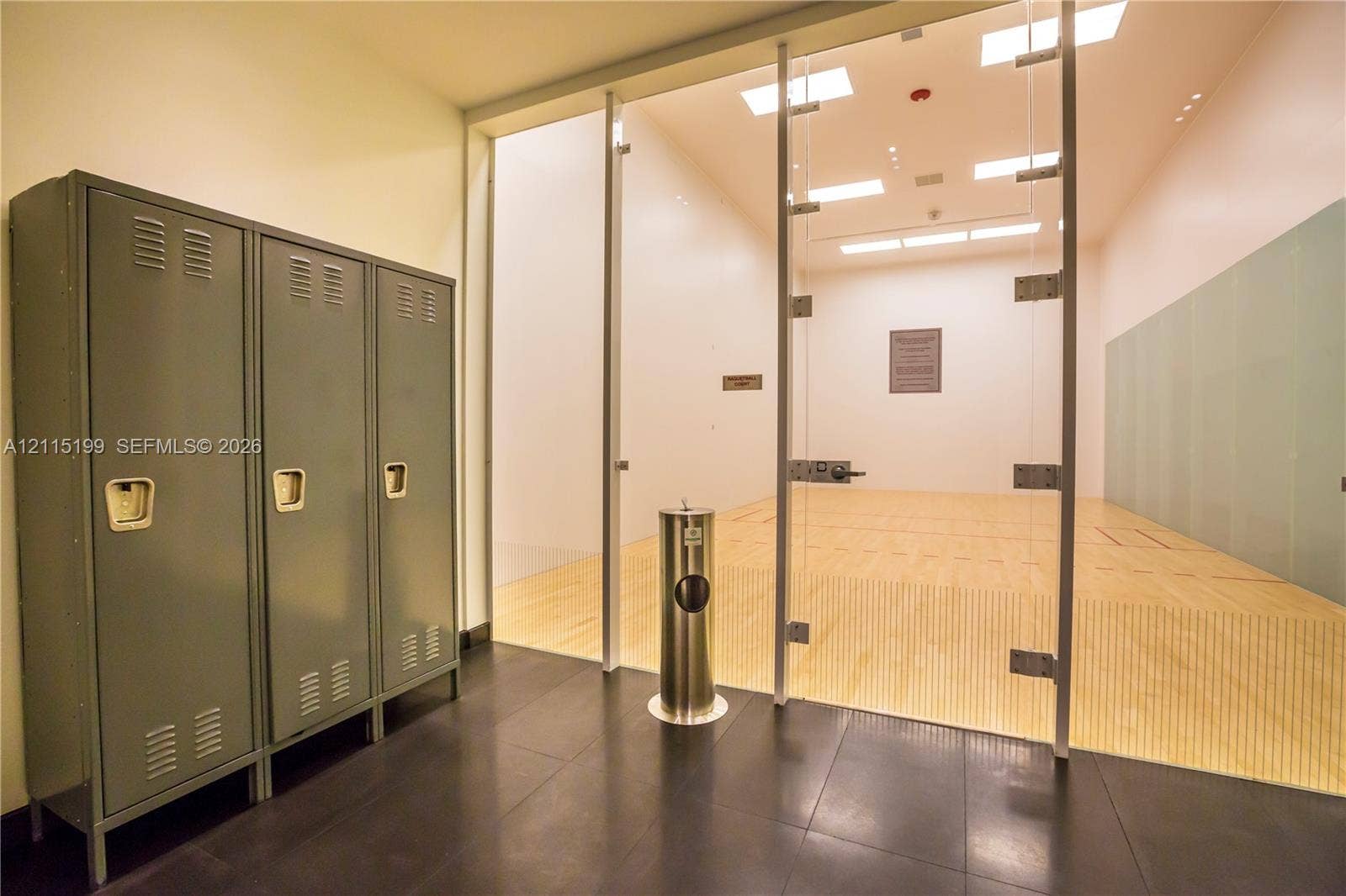 1600 NE 1st Avenue, #3120, Miami, FL 33132 Recreational court featuring wood flooring, high-clearance ceiling with recessed lighting, glass-paneled partition, and industrial-finish metal lockers