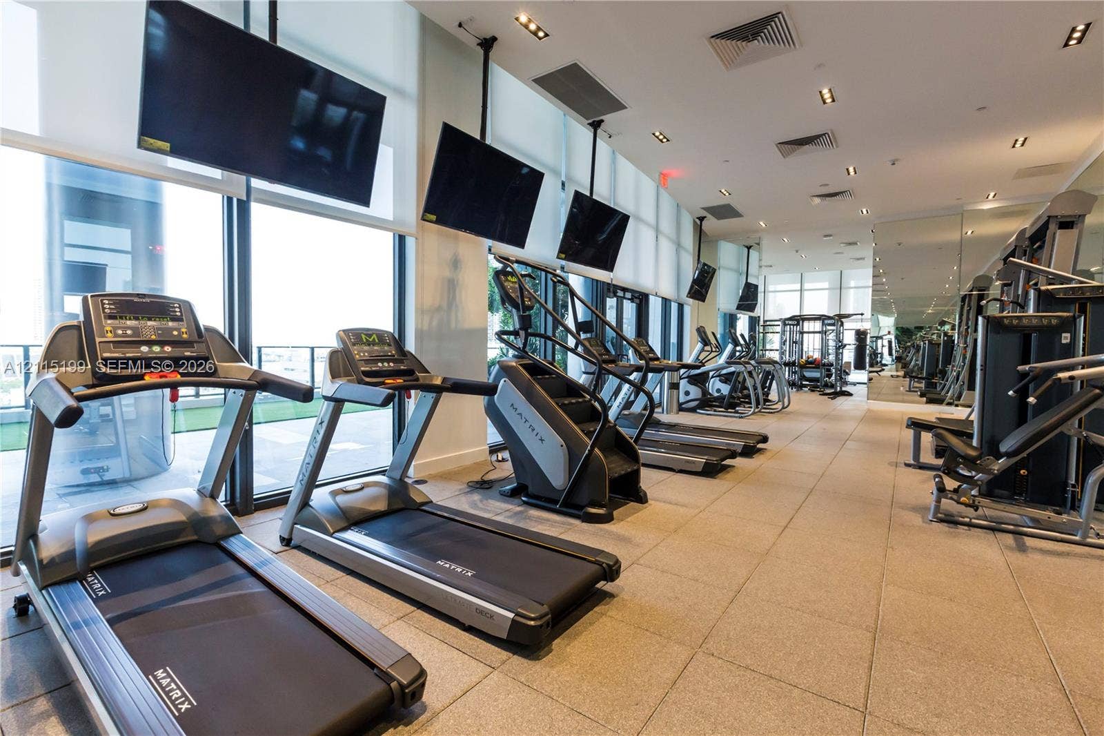 1600 NE 1st Avenue, #3120, Miami, FL 33132 Fitness center featuring floor-to-ceiling windows, tile flooring, recessed ceiling lighting, and wall-mounted televisions