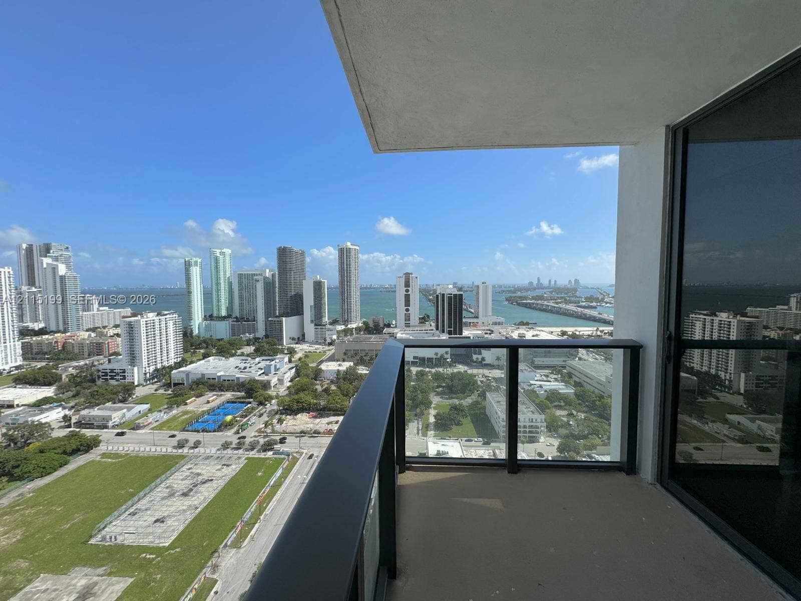 1600 NE 1st Avenue, #3120, Miami, FL 33132 Private balcony featuring a dark metal railing with glass panels and concrete flooring, overlooking the cityscape and water