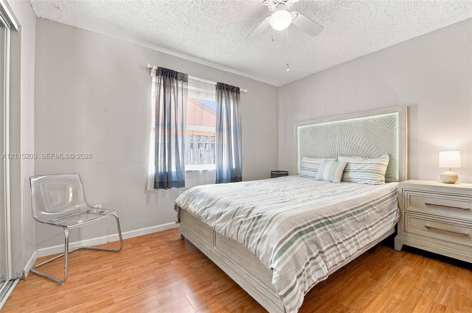 Wood-finish flooring, neutral wall paint, and a central ceiling fan with an integrated light fixture