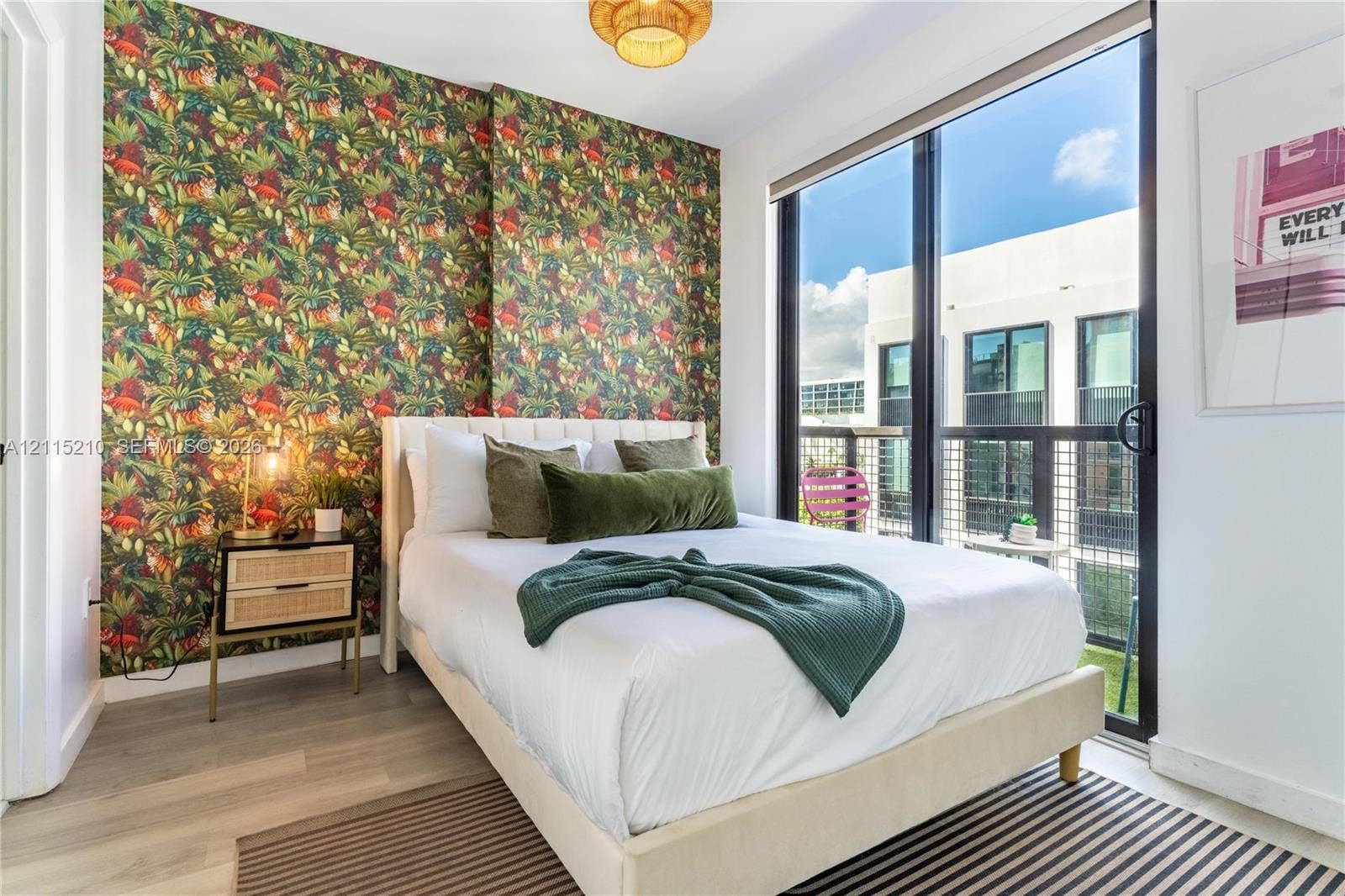 136 NW 26th Street, #507, Miami, FL 33127 Floor-to-ceiling sliding glass doors, private balcony, wood-finish flooring, and statement patterned wallpaper