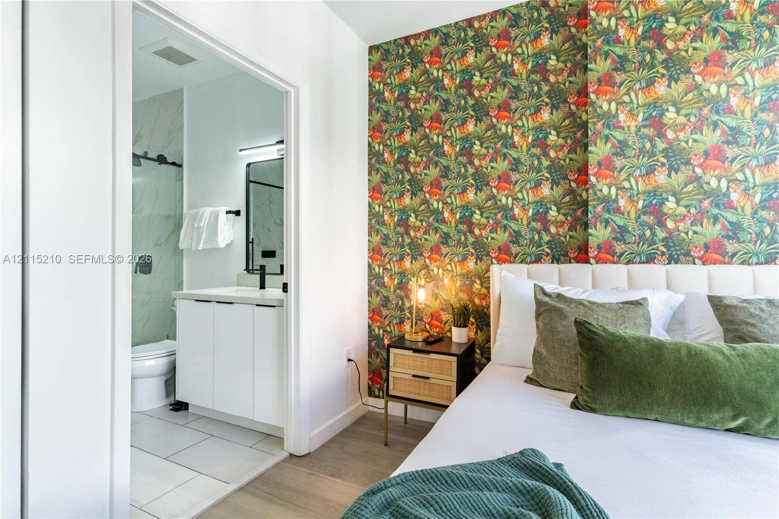 136 NW 26th Street, #507, Miami, FL 33127 Patterned wall covering, light wood-finish flooring, white vanity with rectangular sink, matte black hardware, and large-format tile bathroom flooring