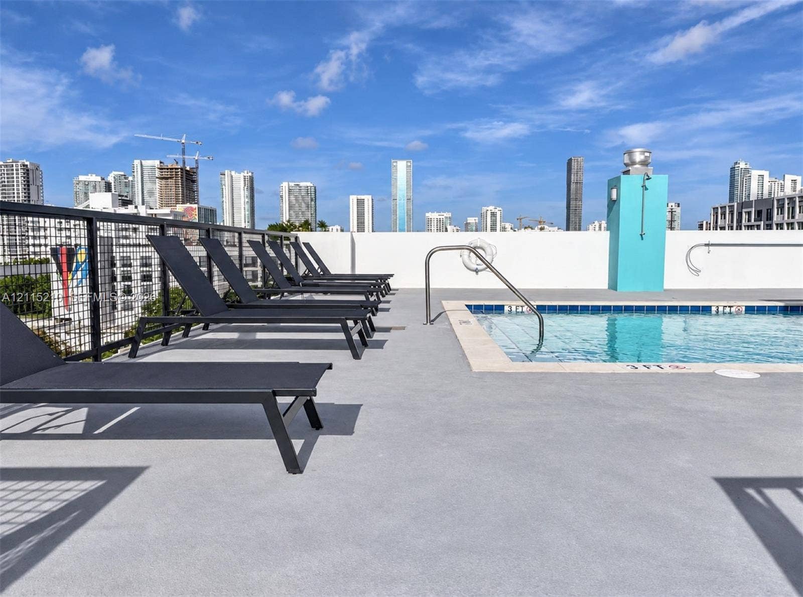 136 NW 26th Street, #507, Miami, FL 33127 Rooftop terrace featuring an outdoor pool with a metal handrail, concrete decking, and a metal grid perimeter railing