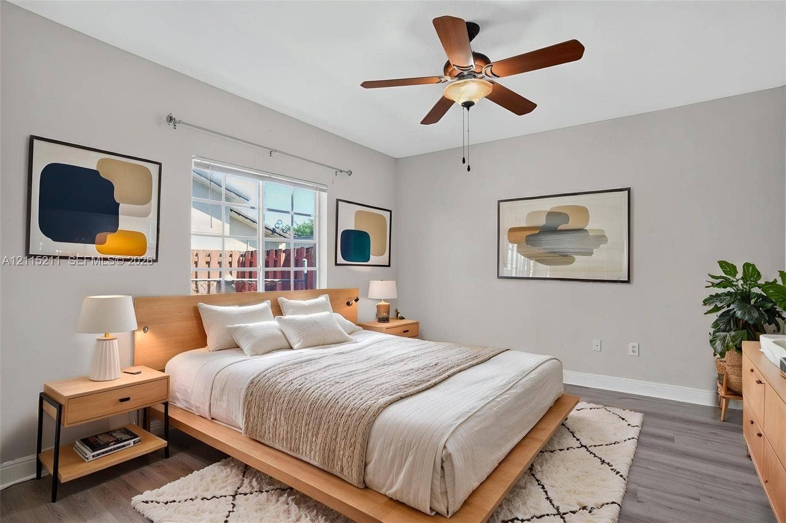 Neutral-toned walls, wood-finish flooring, and a ceiling fan with integrated lighting