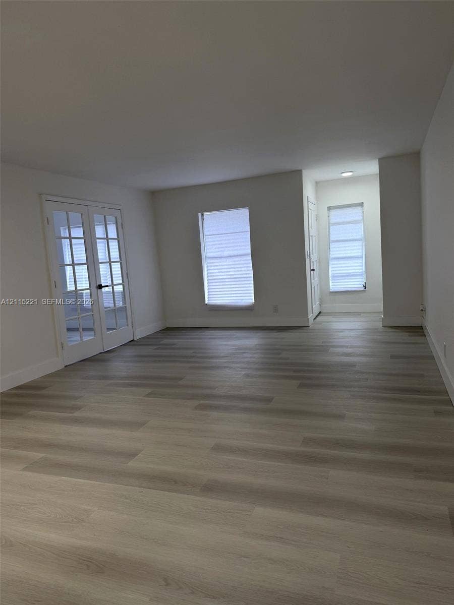 301 Bonaventure Boulevard, #15, Weston, FL 33326 Neutral-toned wood-finish flooring, white walls, and French doors