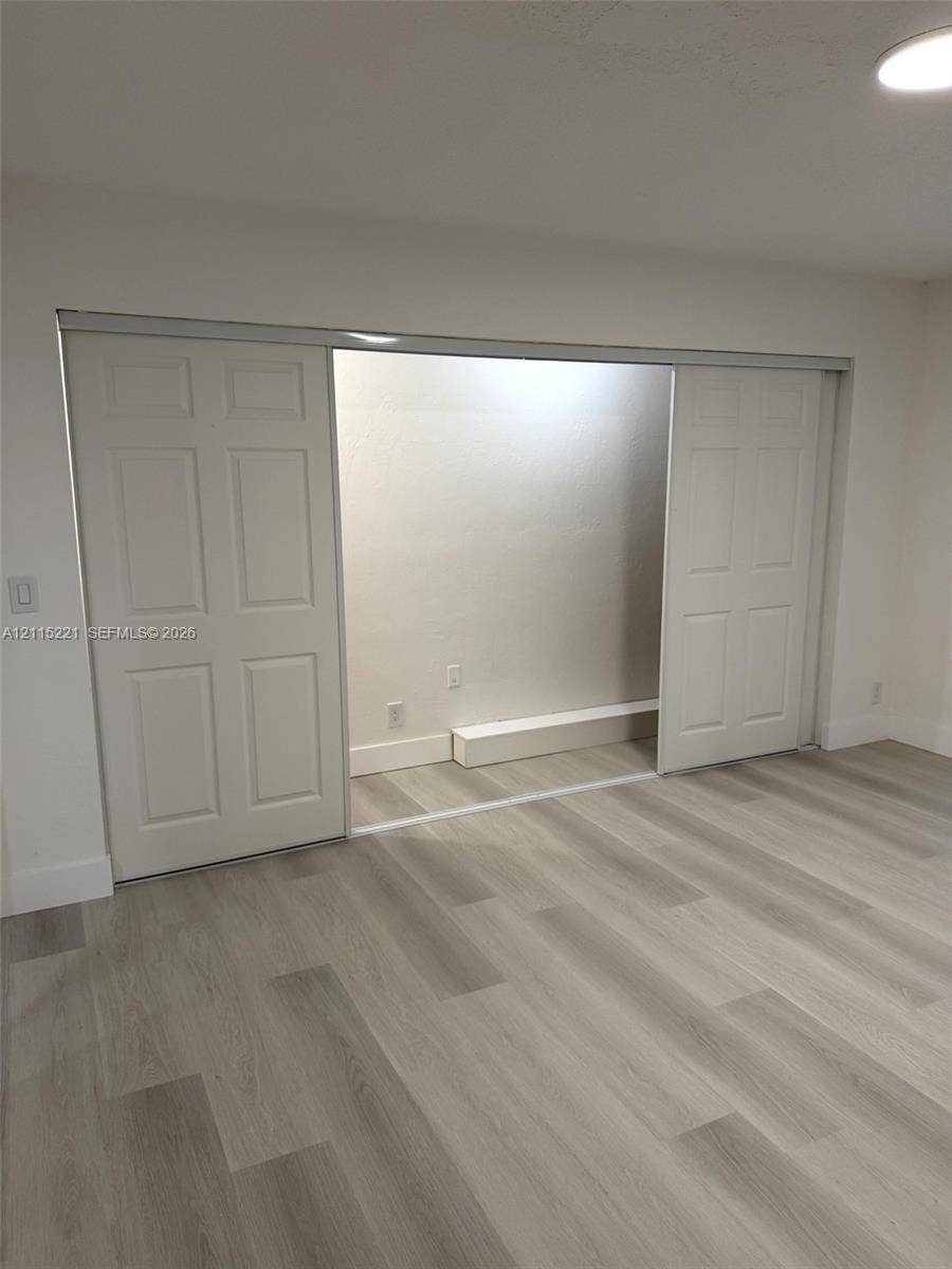 301 Bonaventure Boulevard, #15, Weston, FL 33326 Wood-finish flooring, white four-panel sliding closet doors, and recessed ceiling lighting