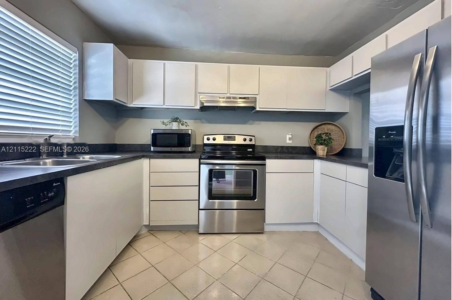 9450 Live Oak Place, #303, Davie, Davie, FL 33324 Kitchen featuring white cabinetry, dark countertops, tile flooring, and stainless steel appliances including a range, dishwasher, and refrigerator