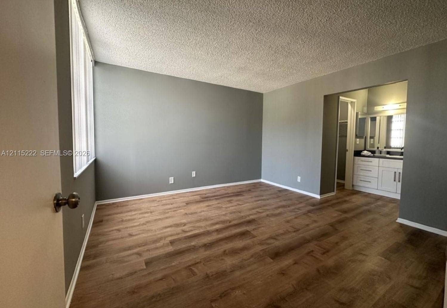 9450 Live Oak Place, #303, Davie, Davie, FL 33324 Spacious room featuring wood-finish flooring, neutral wall tones, and recessed entry to the vanity area