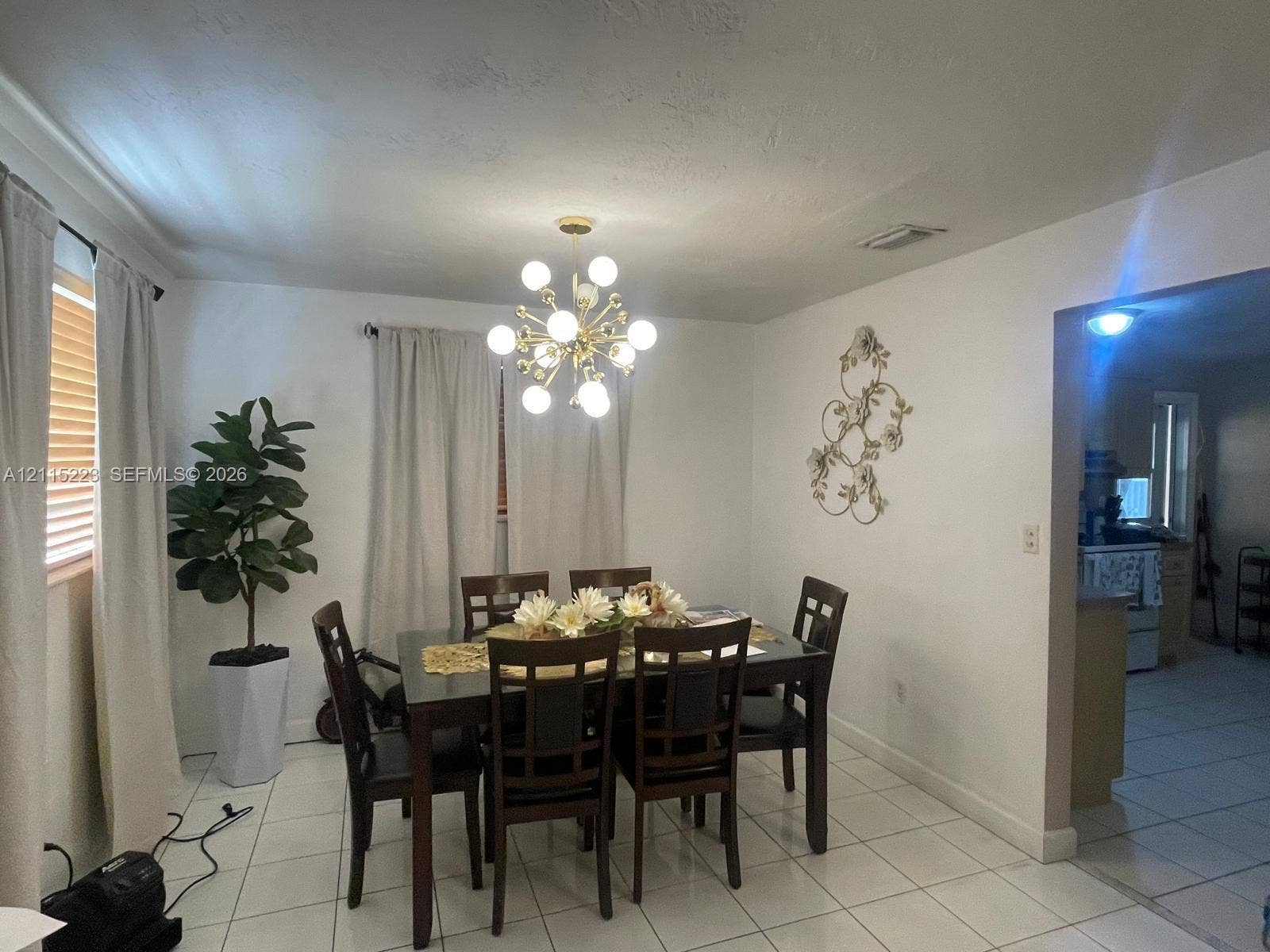 737 SE 8th Place, Hialeah, FL 33010 Dining area featuring white ceramic tile flooring and a multi-globe metallic chandelier
