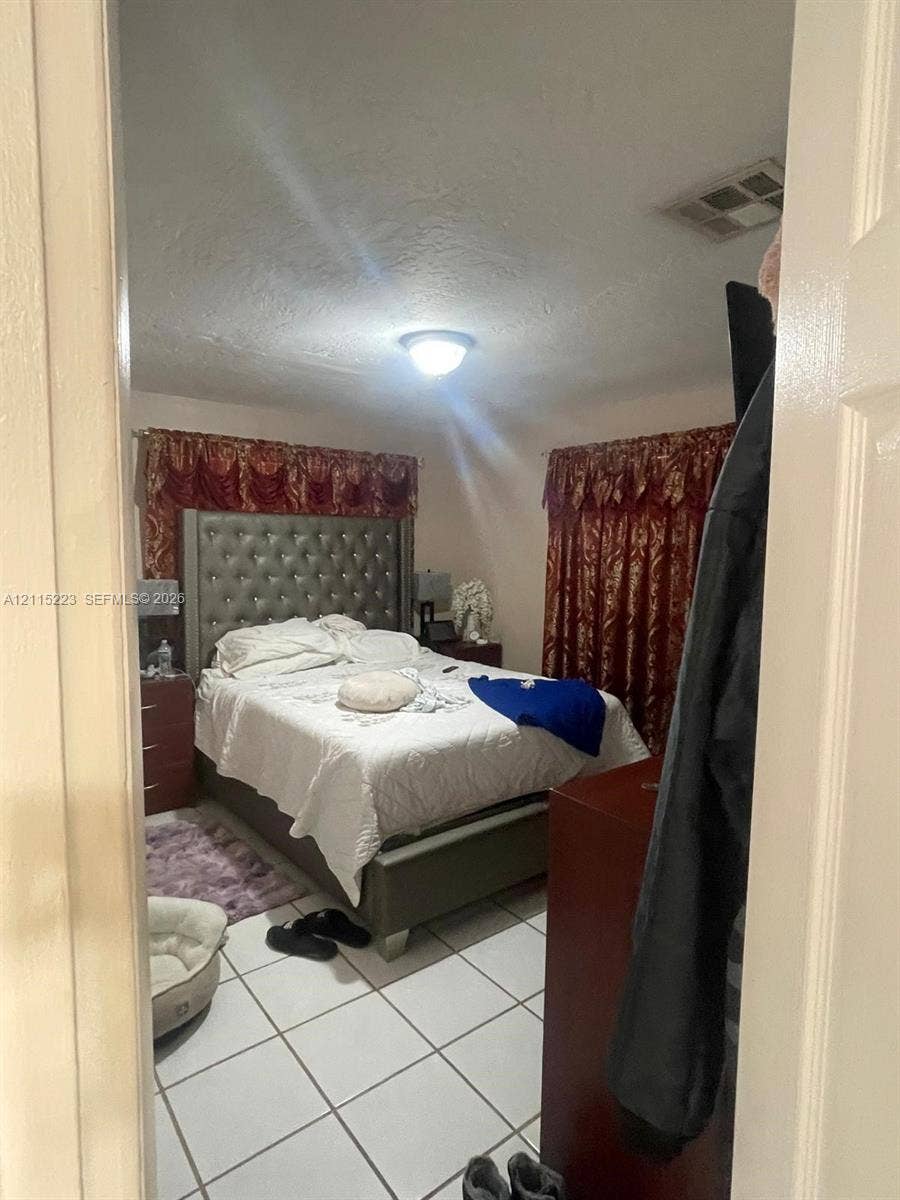 737 SE 8th Place, Hialeah, FL 33010 Room featuring white tile flooring and a central ceiling-mounted light fixture