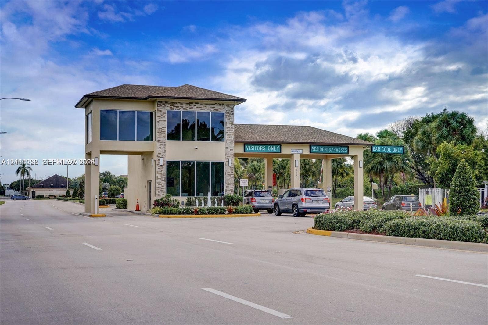 12950 SW 7th Court, #404A, Pembroke Pines, Pembroke Pines, FL 33027 Gated community entrance featuring stone-veneer accents, multi-lane access control, and large-format windows