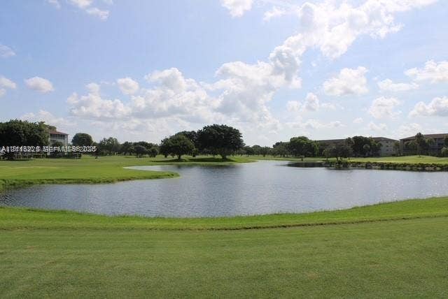 12950 SW 7th Court, #404A, Pembroke Pines, Pembroke Pines, FL 33027 Waterfront grounds featuring a manicured lawn, pond, and mature trees