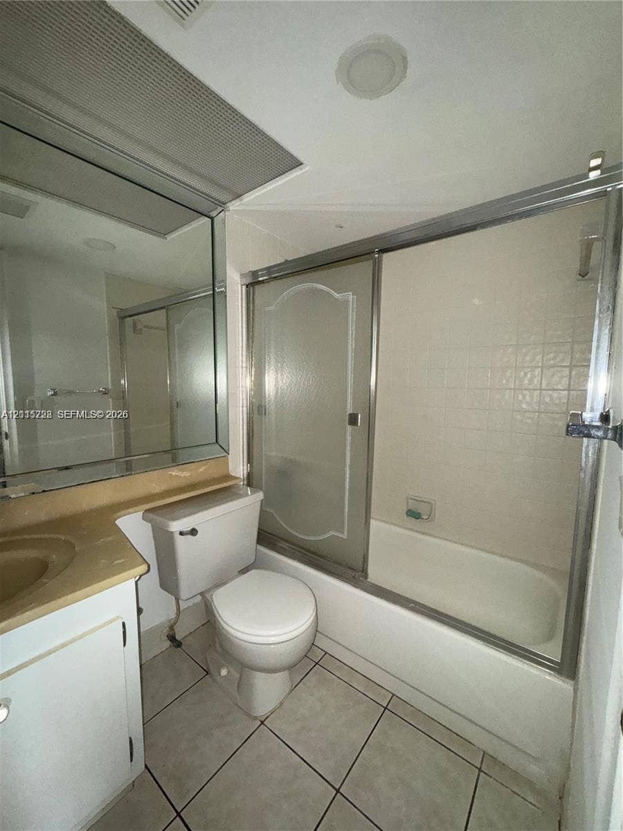 12950 SW 7th Court, #404A, Pembroke Pines, Pembroke Pines, FL 33027 Bathroom featuring tile flooring, a built-in vanity with an integrated sink, a large wall-mounted mirror, and a tub-shower combination with sliding glass doors