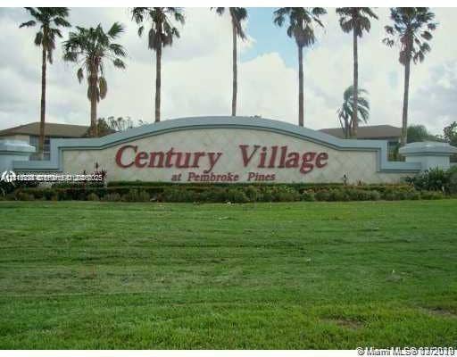 12950 SW 7th Court, #404A, Pembroke Pines, Pembroke Pines, FL 33027 Community monument sign featuring architectural masonry, decorative detailing, and mature palm tree landscaping