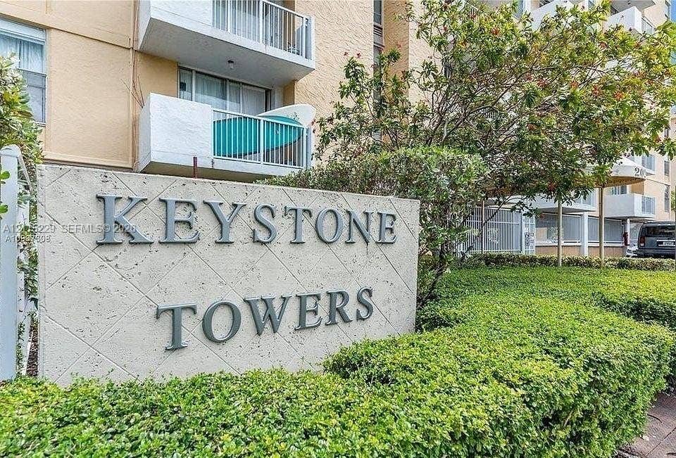 2020 NE 135th Street, #211, North Miami, FL 33181 Textured concrete monument sign featuring dimensional lettering, framed by manicured hedges and mature landscaping