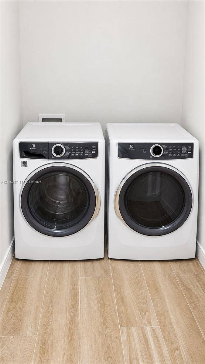 2411 Laguna Circle, #802, North Miami, North Miami, FL 33181 Laundry area featuring front-loading washer and dryer units set upon wood-finish flooring