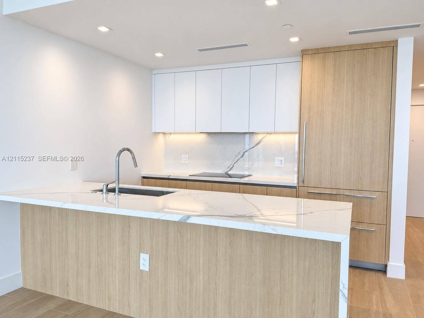 2411 Laguna Circle, #802, North Miami, North Miami, FL 33181 Kitchen featuring a waterfall-edge island with stone-finish countertop, flat-panel cabinetry with wood-finish and matte white cabinetry, integrated refrigerator, and stainless steel gooseneck faucet