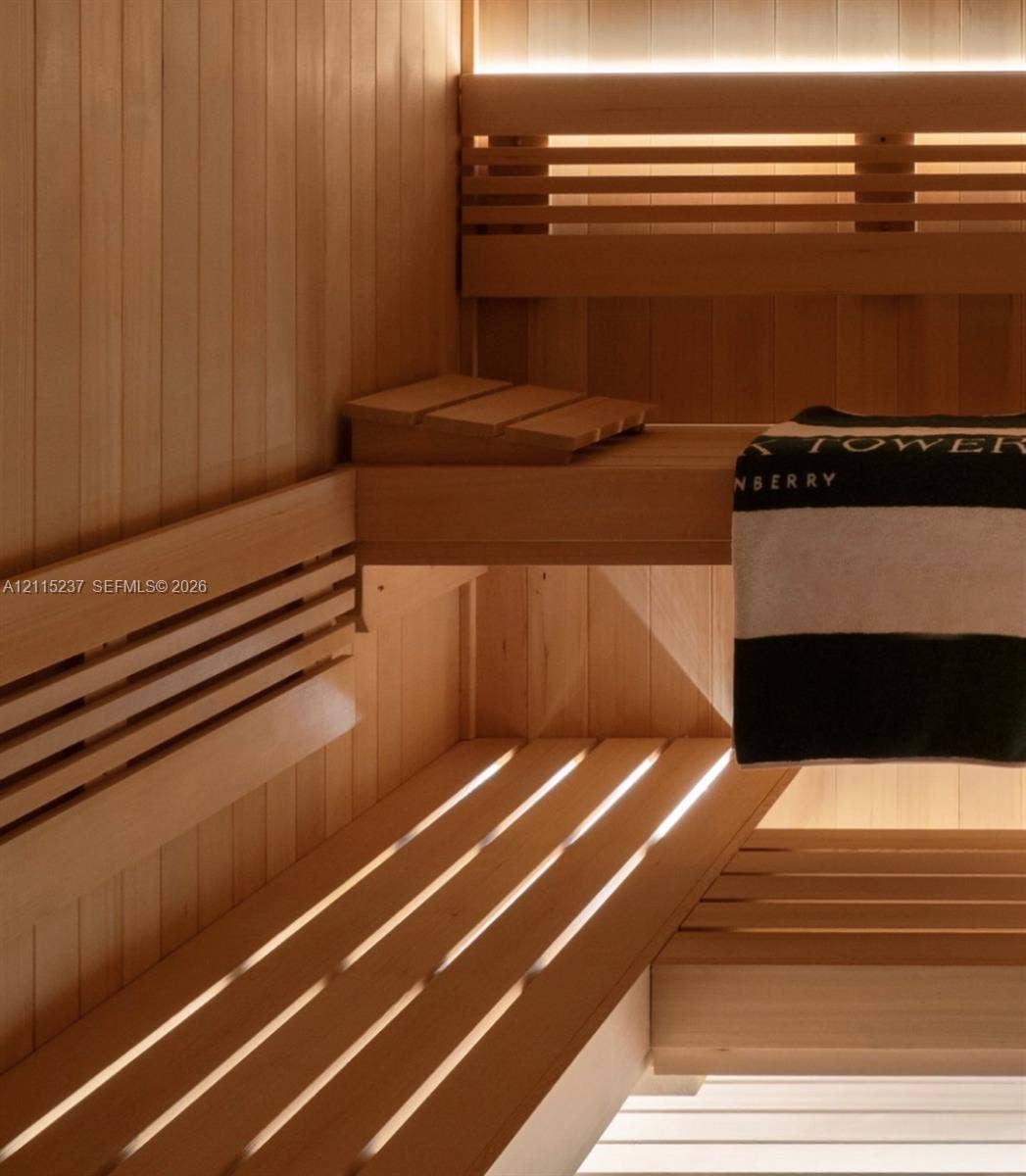 2411 Laguna Circle, #802, North Miami, North Miami, FL 33181 Sauna interior featuring natural wood tongue-and-groove paneling, tiered slatted benches, and integrated recessed accent lighting