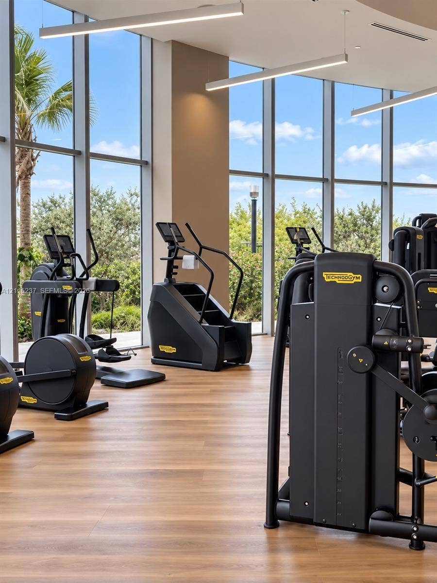2411 Laguna Circle, #802, North Miami, North Miami, FL 33181 Fitness center featuring floor-to-ceiling windows, wood-finish flooring, and recessed linear pendant lighting