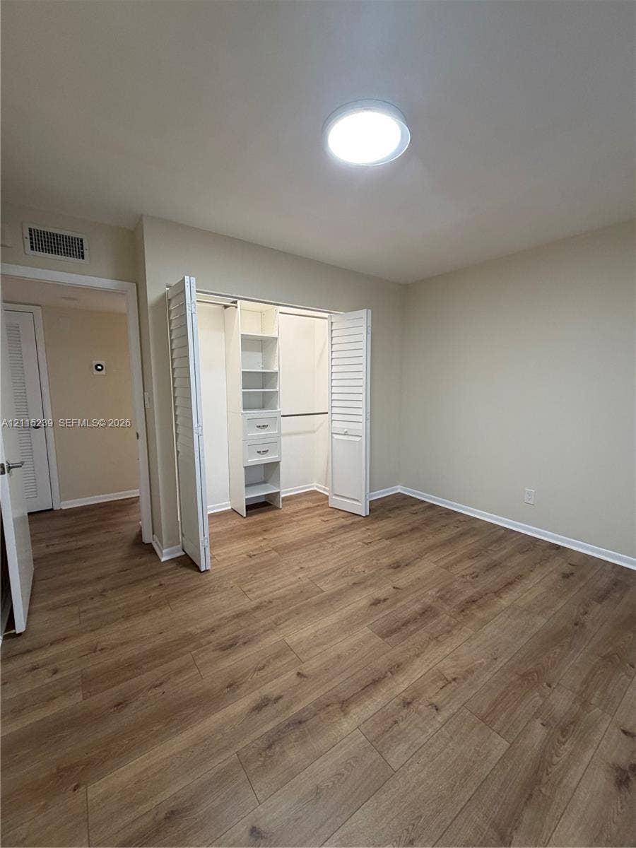 9015 SW 138th Street, #16-2, Miami, Miami, FL 33176 Interior space featuring wood-finish flooring, recessed ceiling lighting, and a closet with bifold louvered doors, built-in shelving, and drawers