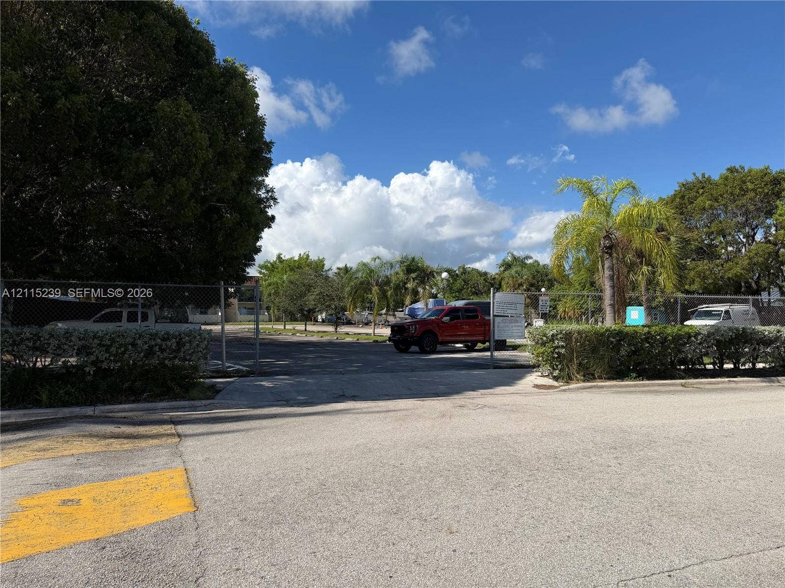 9015 SW 138th Street, #16-2, Miami, Miami, FL 33176 Paved lot featuring a chain-link perimeter fence, gated entrance, and mature landscaping