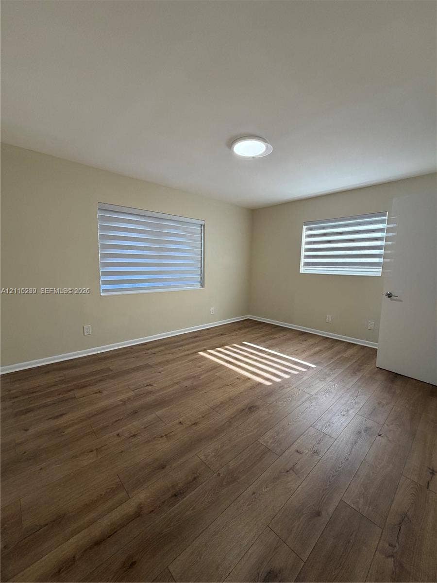 9015 SW 138th Street, #16-2, Miami, Miami, FL 33176 Room featuring wood-finish flooring, dual windows with fitted shades, and a flush-mount ceiling light fixture