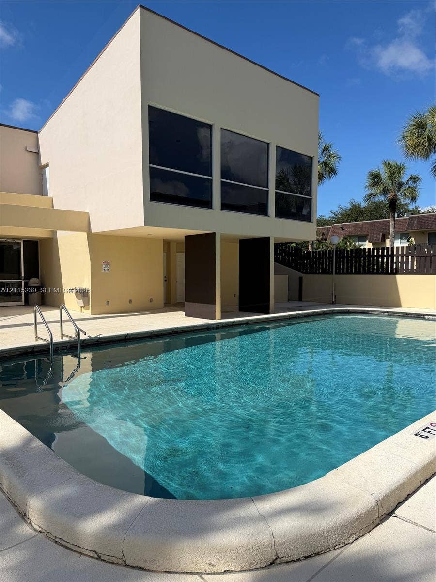 9015 SW 138th Street, #16-2, Miami, Miami, FL 33176 In-ground pool featuring a concrete deck, metal handrail, and architectural pillars